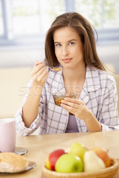 Glimlachende vrouw granen vergadering keukentafel ontbijt glimlach Stockfoto © nyul