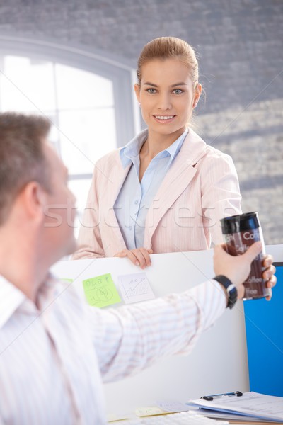Attractive woman passing coffee to colleague Stock photo © nyul