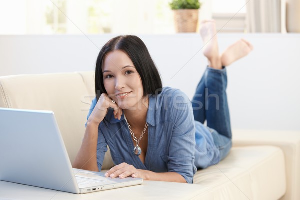 Portrait of smiling woman on sofa with laptop Stock photo © nyul