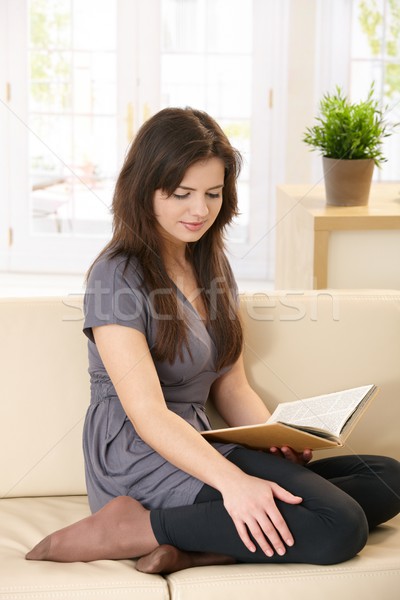 Stock photo: Pretty girl on couch with book