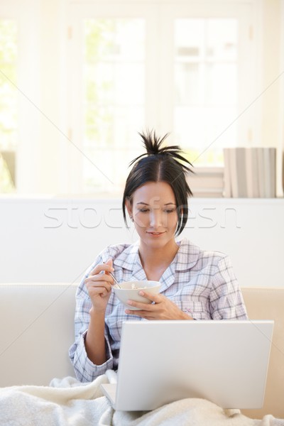 Vrouw granen naar laptop ontbijt laptop computer Stockfoto © nyul