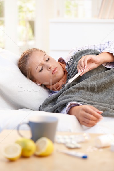 Jonge vrouwelijke griep leggen bed home Stockfoto © nyul