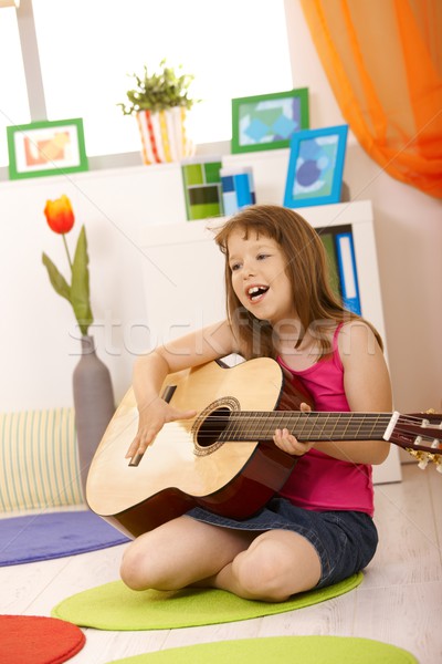 Portret uczennica gitara śpiewu posiedzenia salon Zdjęcia stock © nyul