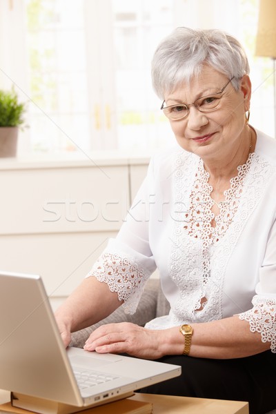 Kıdemli kadın dizüstü bilgisayar kullanıyorsanız bilgisayar ev Stok fotoğraf © nyul