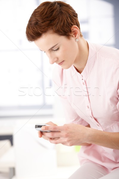 Fiatal nő sms chat portré arc telefon munka Stock fotó © nyul