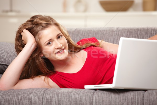 Stockfoto: Glimlachend · teen · laptop · sofa · home · tienermeisje