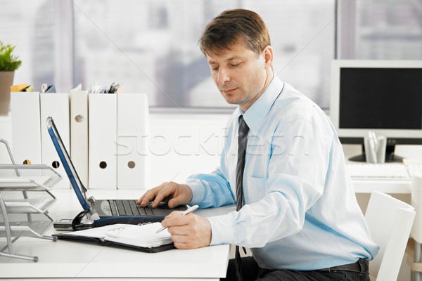 Businessman searching in personal organizer Stock photo © nyul