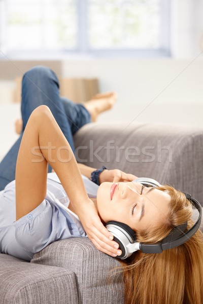 Young woman listening music laying on sofa Stock photo © nyul