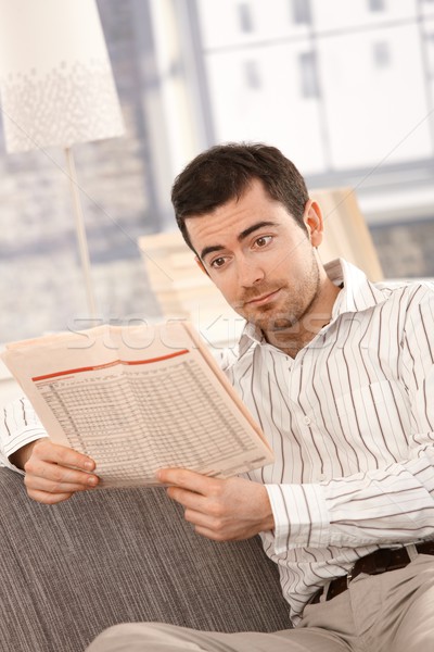 Young male reading bad news from newspaper Stock photo © nyul