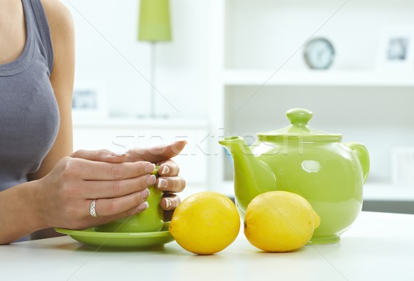 Női kezek tart teáscsésze asztal zöld Stock fotó © nyul