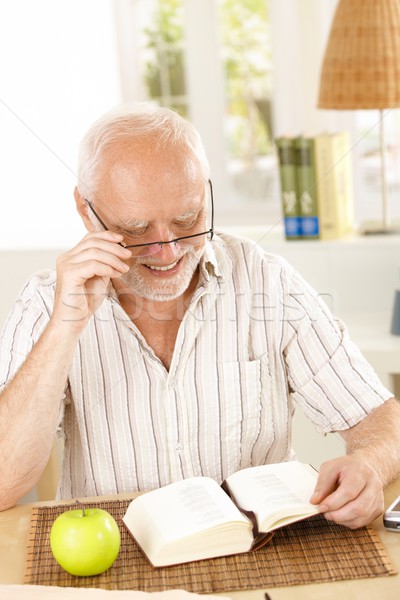 Laughing pensioner reading book Stock photo © nyul