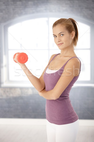 Pretty young woman using dumbbell Stock photo © nyul