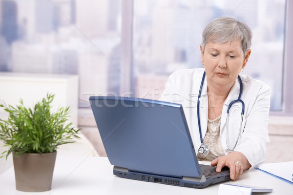 Senior doctor looking at screen Stock photo © nyul