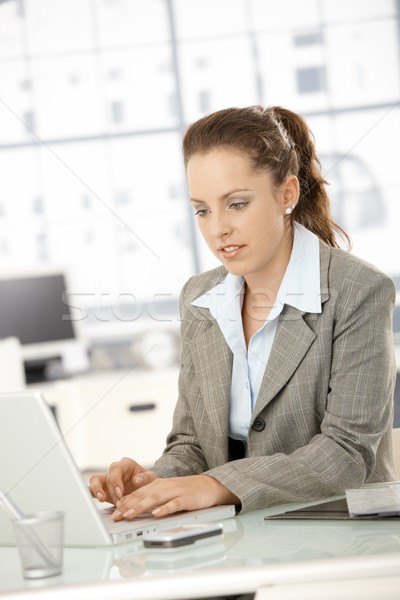 Stock photo: Attractive woman working on laptop in office