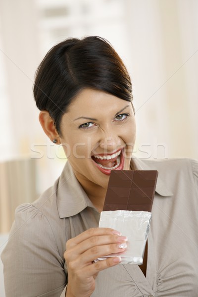 Portrait of excited woman biting chocolate Stock photo © nyul