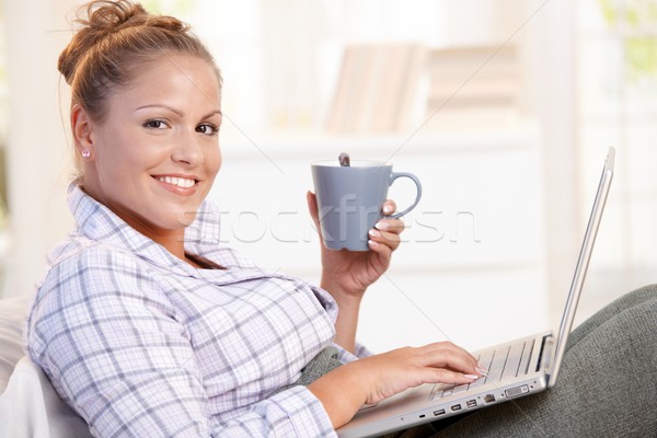 Jonge vrouw met behulp van laptop bed drinken thee jonge Stockfoto © nyul
