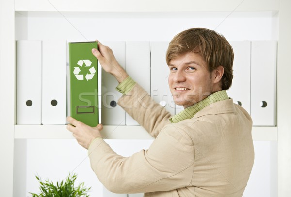 Businessman removing green folder from shelf Stock photo © nyul