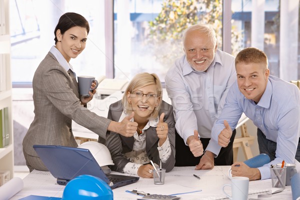 Happy businessteam giving thumbs up at work Stock photo © nyul