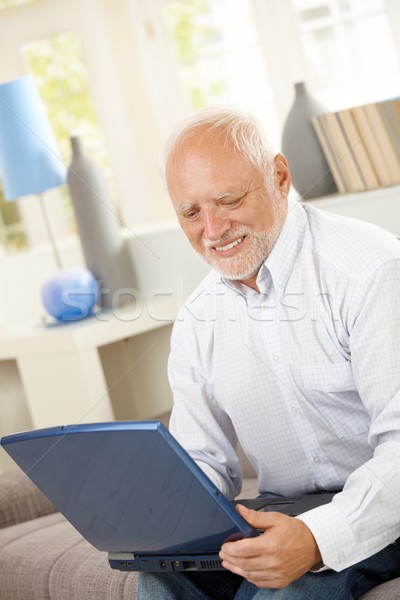 Glimlachend ouderen man naar computerscherm laptop computer Stockfoto © nyul