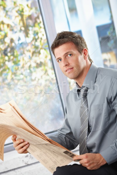 Businessman holding papers looking at camera Stock photo © nyul