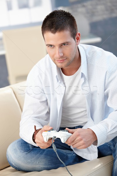 Handsome man playing video game at home smiling Stock photo © nyul