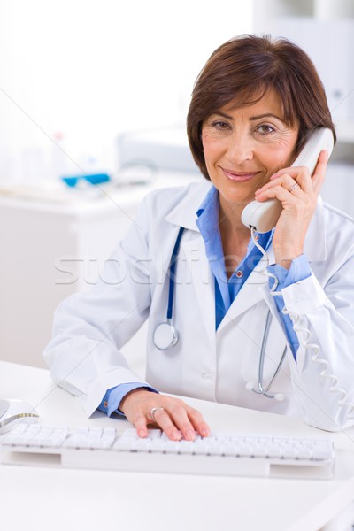 Foto stock: Médico · llamando · teléfono · altos · femenino · sonriendo