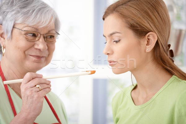 Attractive woman tasting food while cooking Stock photo © nyul