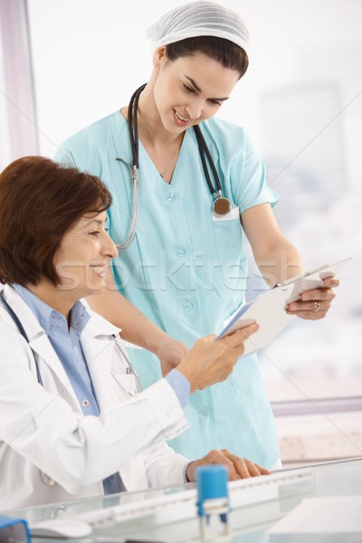 Smiling physician working with nurse Stock photo © nyul