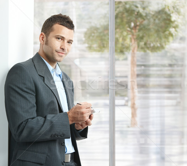 Geschäftsmann Smartphone jungen stehen Büro Lobby Stock foto © nyul