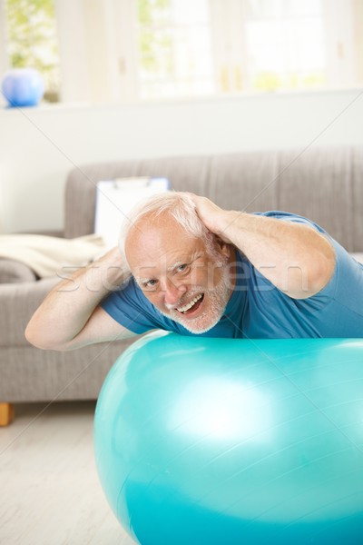 Happy active senior exercises on fit ball Stock photo © nyul