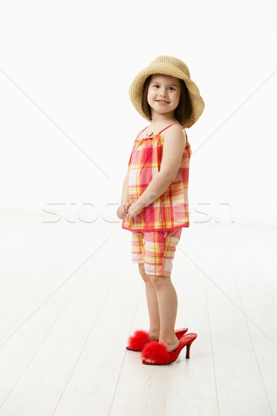 Stock photo: Little daughter trying mothers shoes