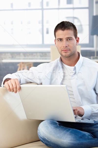 Goodlooking man working at home on laptop Stock photo © nyul