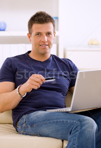 Foto stock: Homem · compras · on-line · moço · casa · usando · laptop