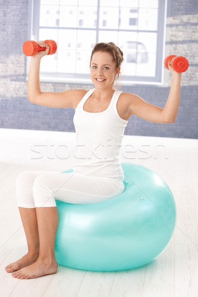 Pretty girl exercising with dumbbells on fitball Stock photo © nyul