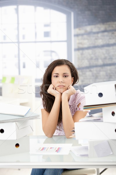 Stock photo: Troubled secretary sitting among folders