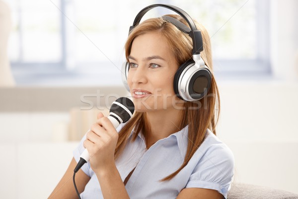 Young woman singing with microphone smiling Stock photo © nyul