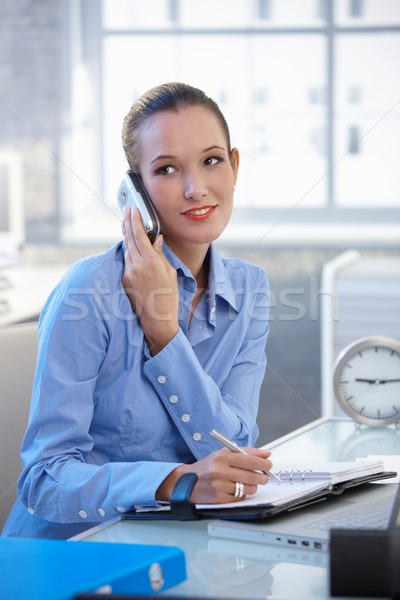 Stockfoto: Glimlachend · zakenvrouw · praten · mobieltje · schrijven · notebook