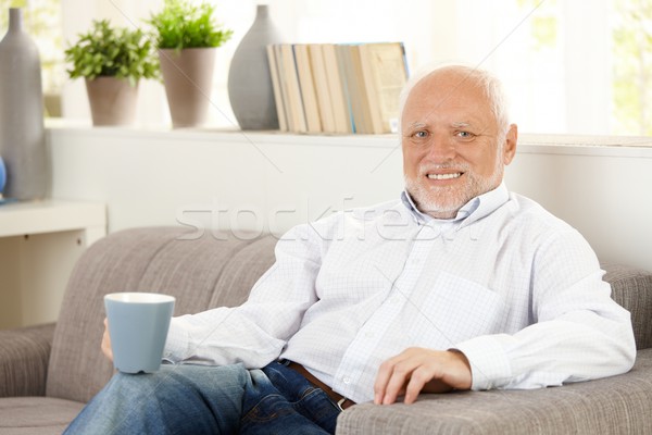 Glimlachend ouderen man koffie sofa home Stockfoto © nyul