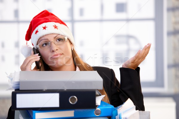 Young female in santa hat troubled in office Stock photo © nyul