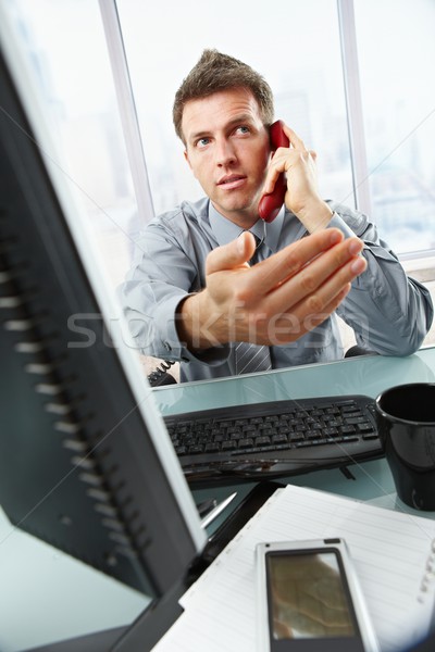 Businessman on call waving working in office Stock photo © nyul