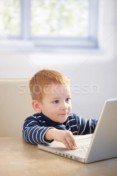 Sweet gingerish kid playing video game on laptop Stock photo © nyul