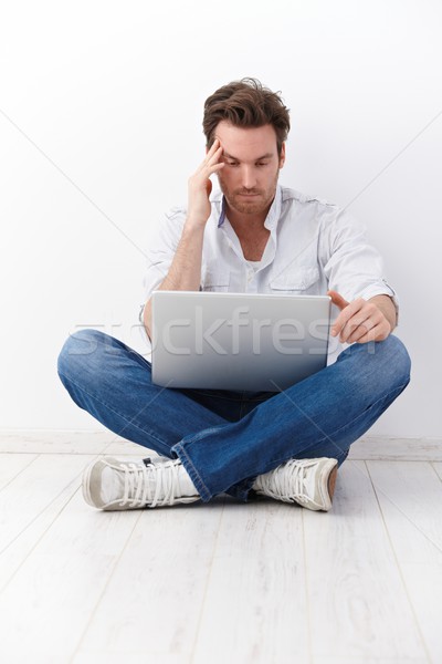 Stock photo: Young man in tailor seat browsing internet�