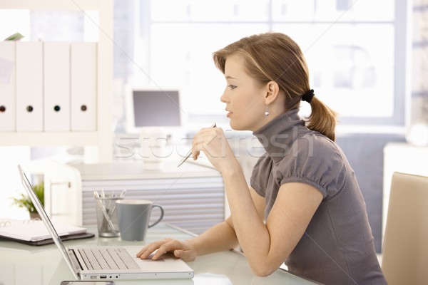Atractiv lucrator de birou şedinţei birou folosind laptop calculator Imagine de stoc © nyul