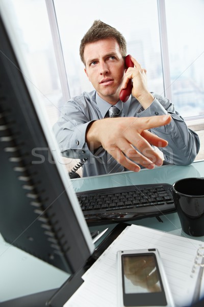 Businessman calling and gesturing in office Stock photo © nyul