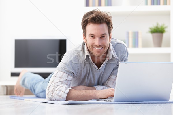 Casual man laying on floor at home smiling Stock photo © nyul