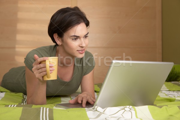 Stockfoto: Vrouw · bed · met · behulp · van · laptop · computer · koffiemok