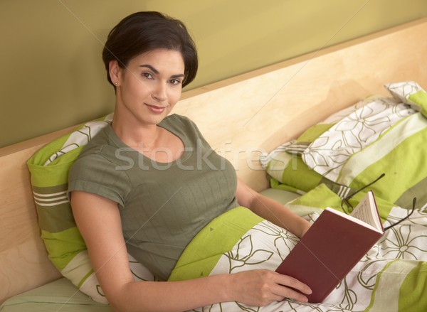 肖像 笑顔の女性 読む ベッド 見える カメラ ストックフォト © nyul
