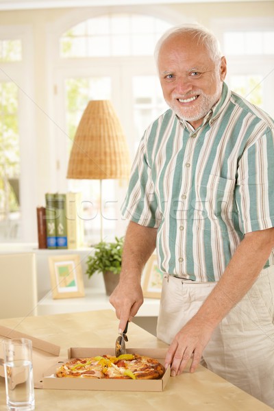 Smiling senior man cutting up pizza Stock photo © nyul
