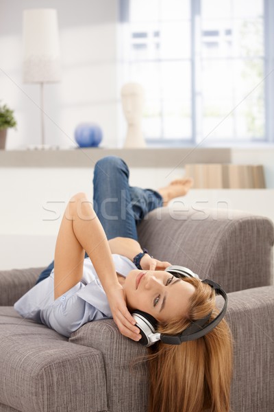 Attractive female laying on sofa listening music Stock photo © nyul