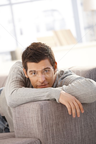 Portré jóképű fiatalember kanapé mosolyog néz Stock fotó © nyul